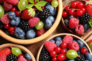 Photo of Mix of ripe berries on wooden table, top view