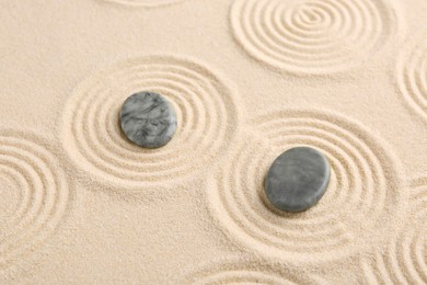 Photo of Zen garden stones on beige sand with pattern