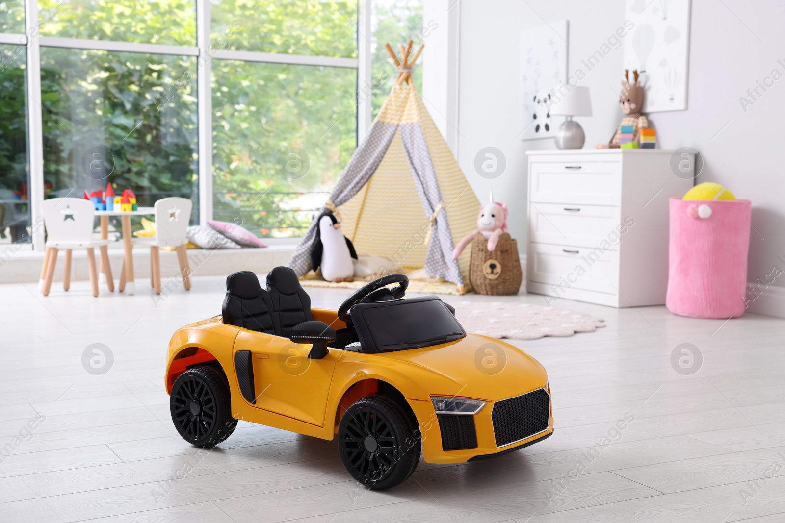 Photo of Yellow car in room at home. Child's toy