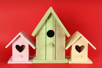 Photo of Beautiful wooden bird houses on red background