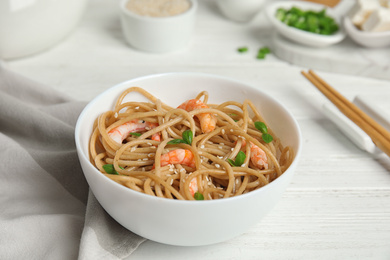 Tasty buckwheat noodles with shrimps served on white wooden table