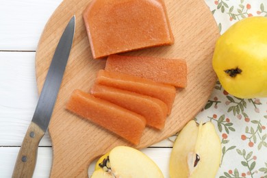Photo of Tasty sweet quince paste, fresh fruits and knife on white wooden table, flat lay