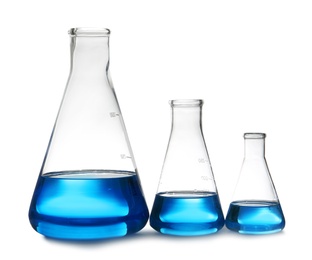 Photo of Conical flasks with liquid on table against white background. Laboratory analysis