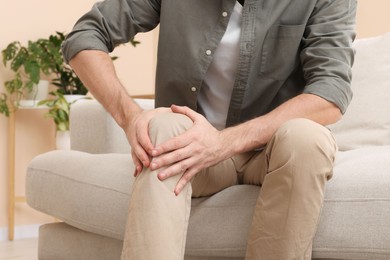 Photo of Man suffering from pain in his leg at home, closeup. Arthritis symptoms