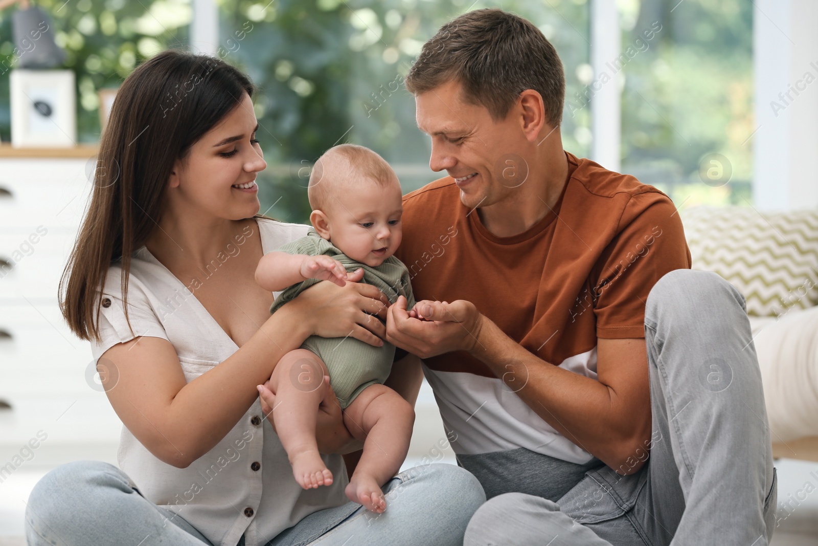 Photo of Portrait of happy family with their cute baby at home