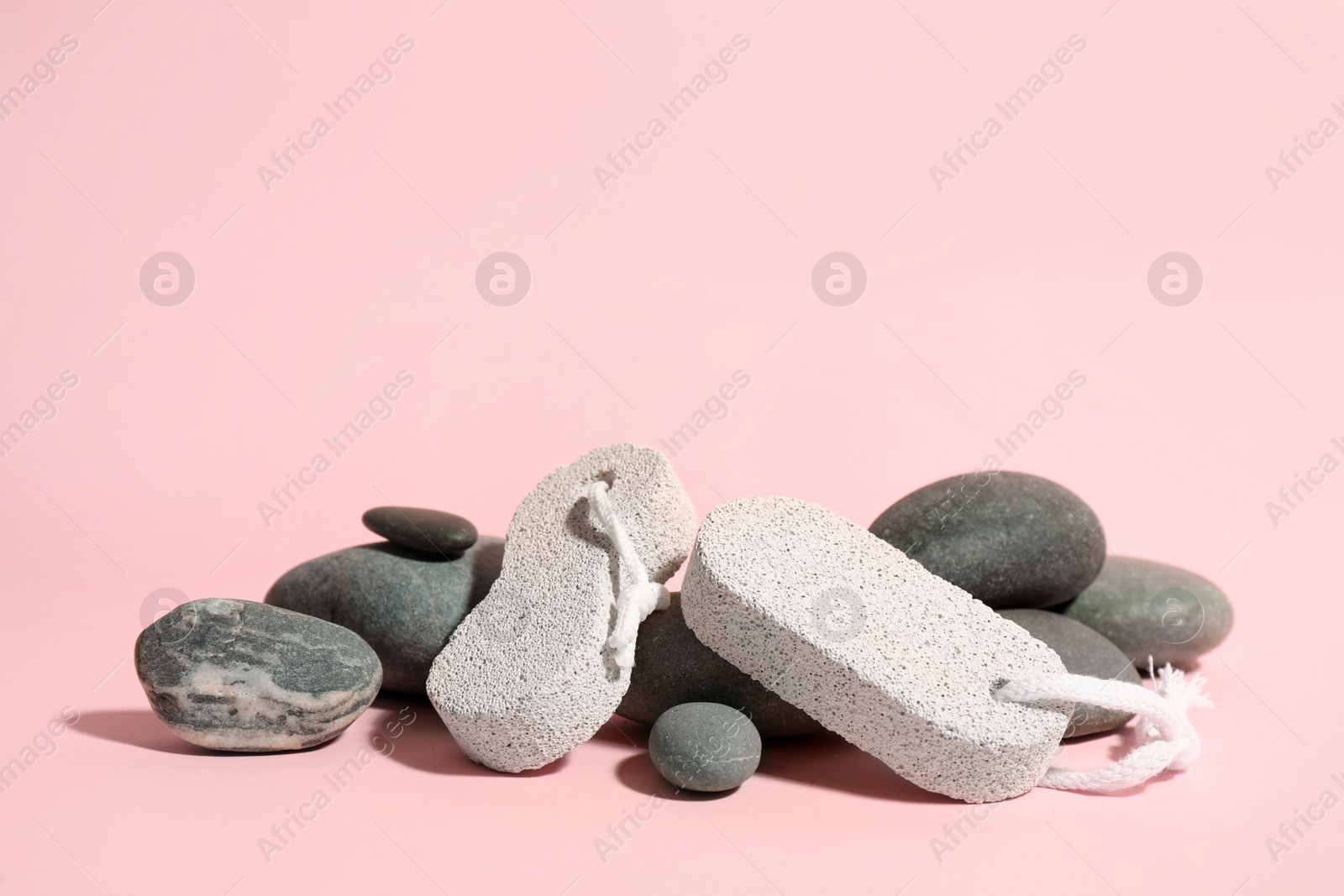 Photo of Pumice and spa stones on pink background, space for text