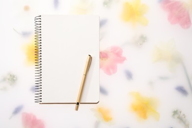 Photo of Guest list. Notebook and pen on spring floral background, flat lay. Space for text