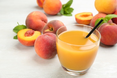Photo of Natural freshly made peach juice on white table, closeup