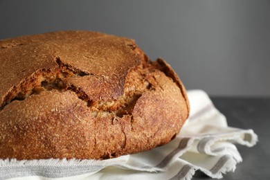 Photo of Freshly baked sourdough bread on table against grey background, closeup. Space for text