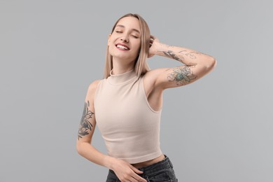 Portrait of beautiful tattooed woman on gray background