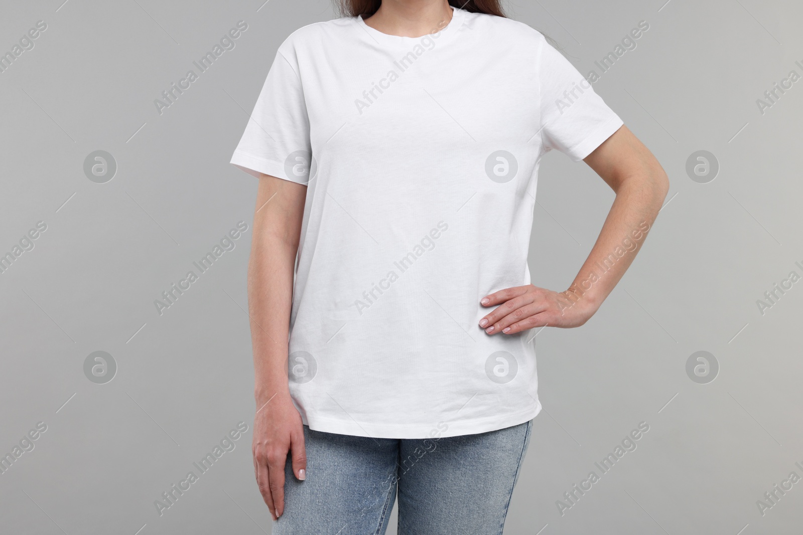 Photo of Woman in white t-shirt on grey background, closeup