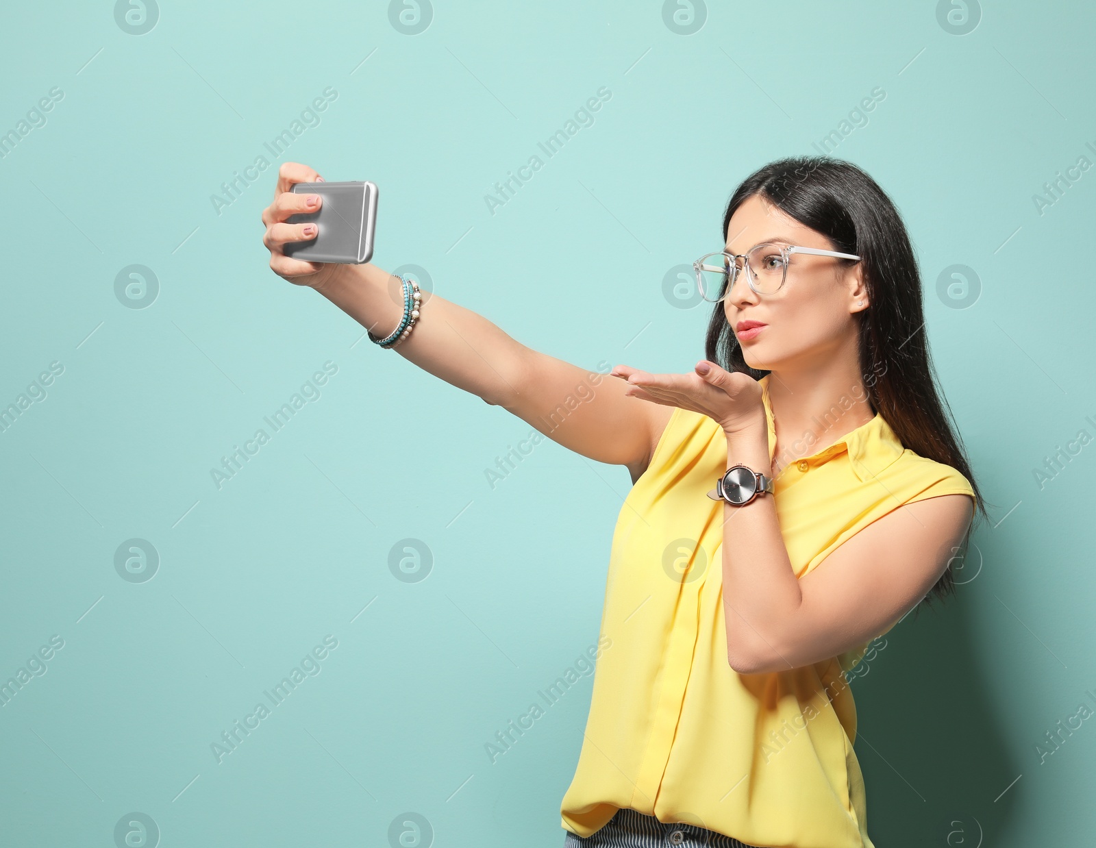 Photo of Attractive young woman taking selfie on color background