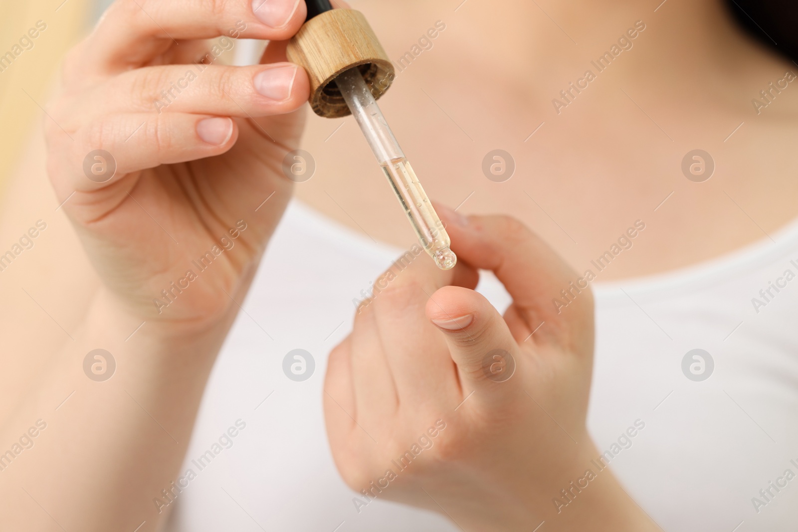 Photo of Woman applying essential oil onto hand, closeup