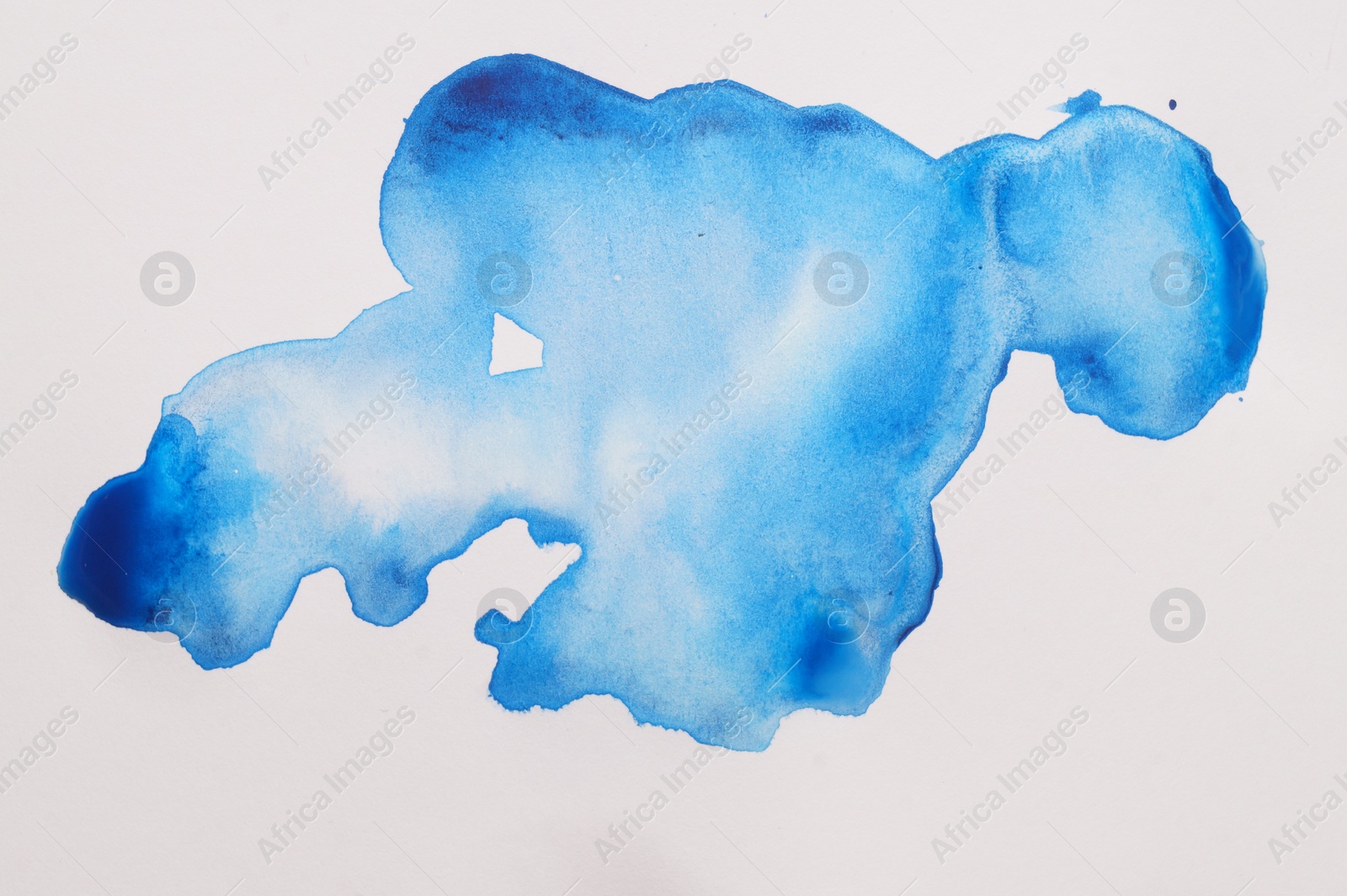 Photo of Blot of light blue watercolor paint on white paper, top view