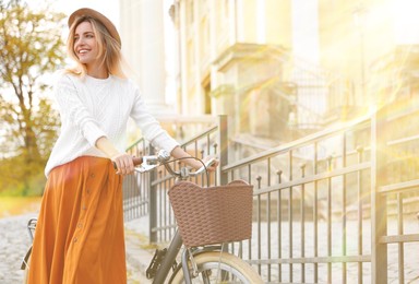 Beautiful young woman with bicycle outdoors on sunny day. Space for text