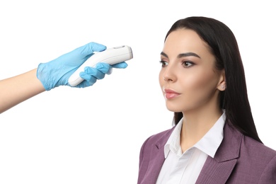 Doctor measuring woman's temperature on white background, closeup. Prevent spreading of Covid-19