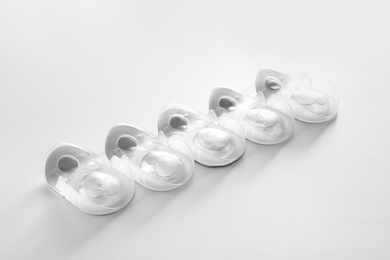 Photo of Packages with contact lenses on white background