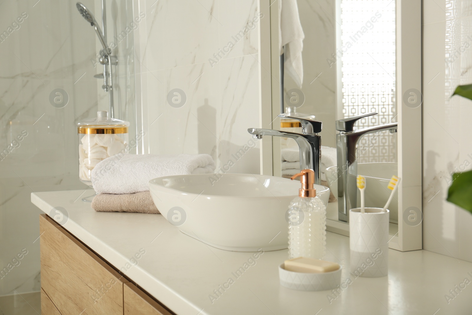 Photo of Toiletries near vessel sink and mirror in bathroom