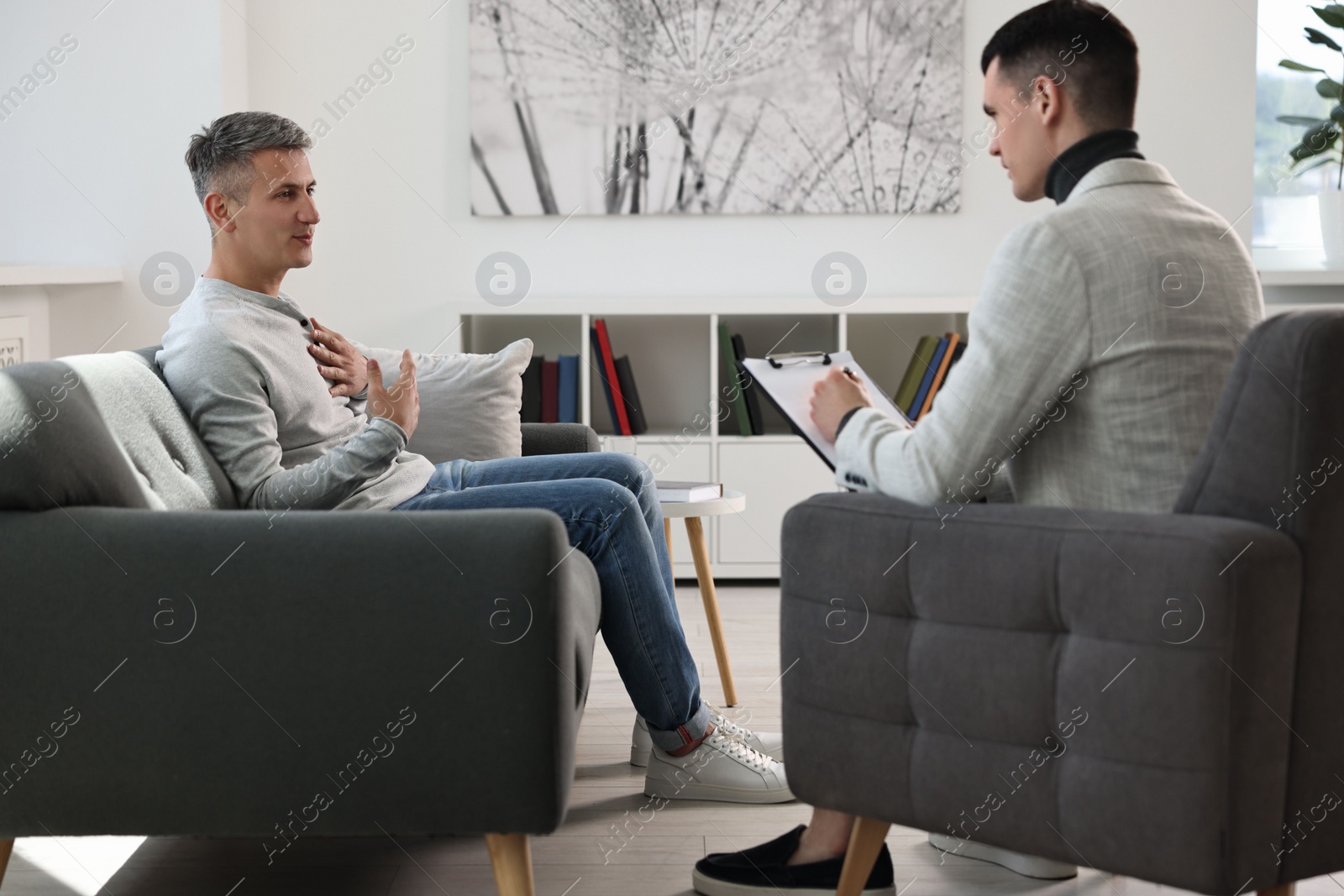 Photo of Professional psychotherapist working with patient in office