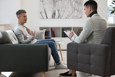 Photo of Professional psychotherapist working with patient in office