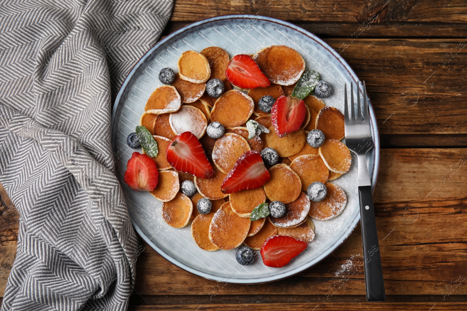 Photo of Cereal pancakes with berries served on wooden table, flat lay