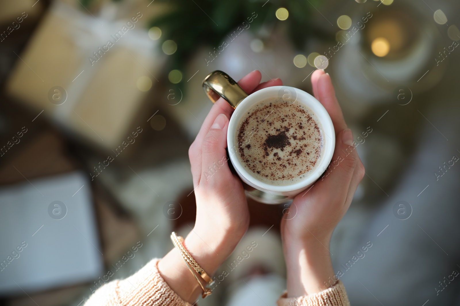 Photo of Woman with cup of cocoa indoors, top view. Christmas mood