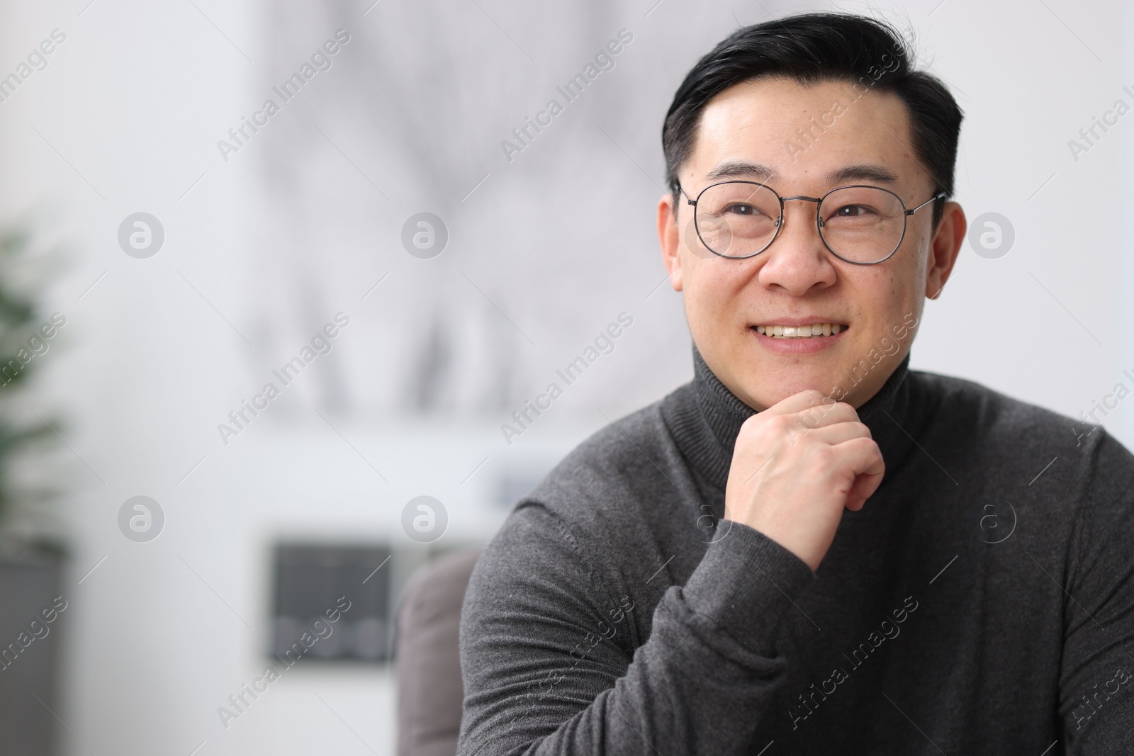 Photo of Portrait of smiling businessman on blurred background. Space for text