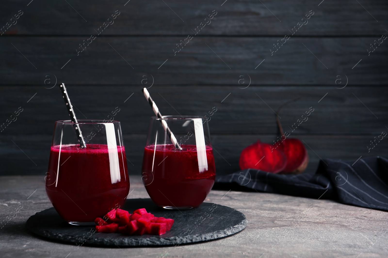 Photo of Slate plate with glasses of beet smoothies on table. Space for text