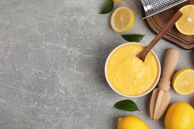 Delicious lemon curd and fresh fruits on light grey table, flat lay. Space for text