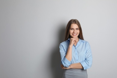 Beautiful real estate agent on grey background