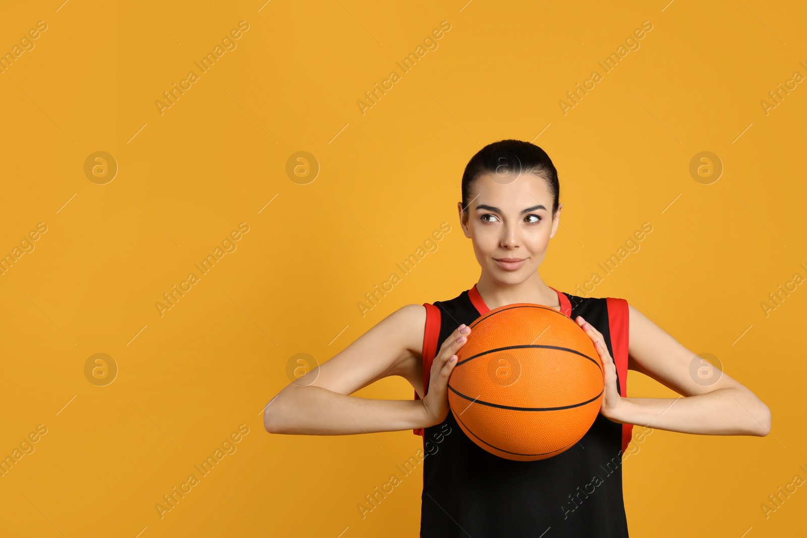 Photo of Basketball player with ball on yellow background. Space for text