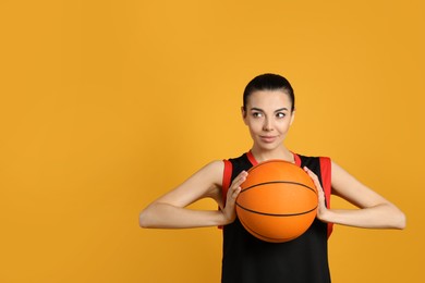 Basketball player with ball on yellow background. Space for text