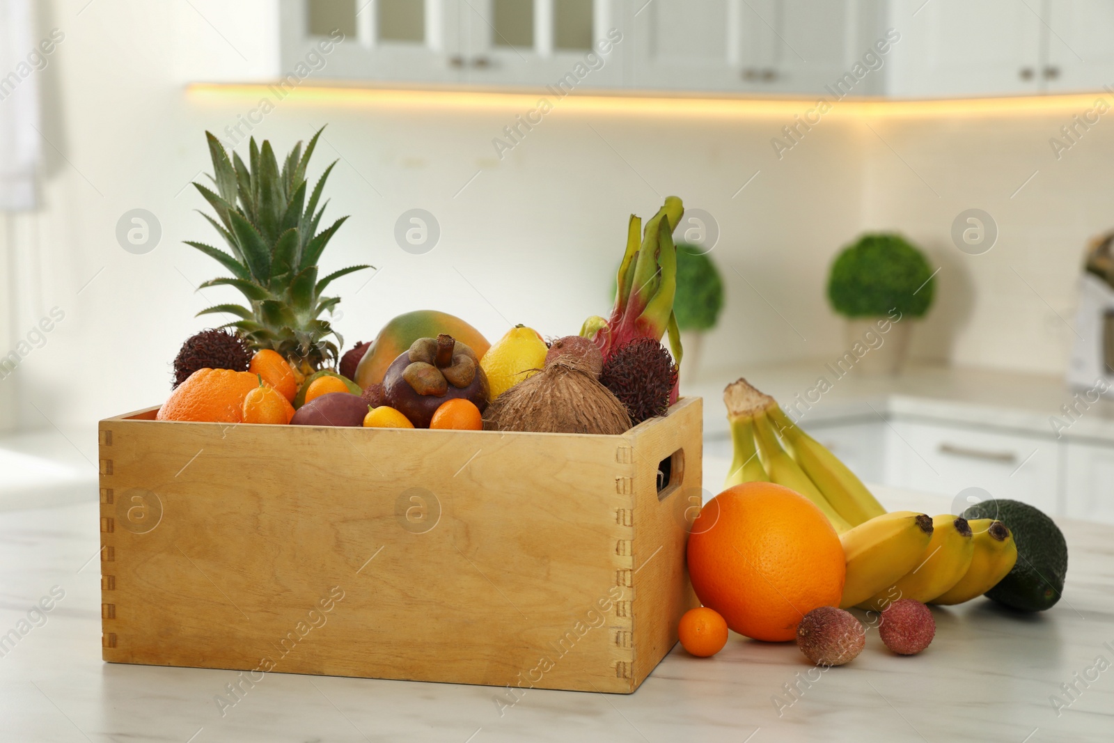 Photo of Assortment of exotic fruits on table in kitchen