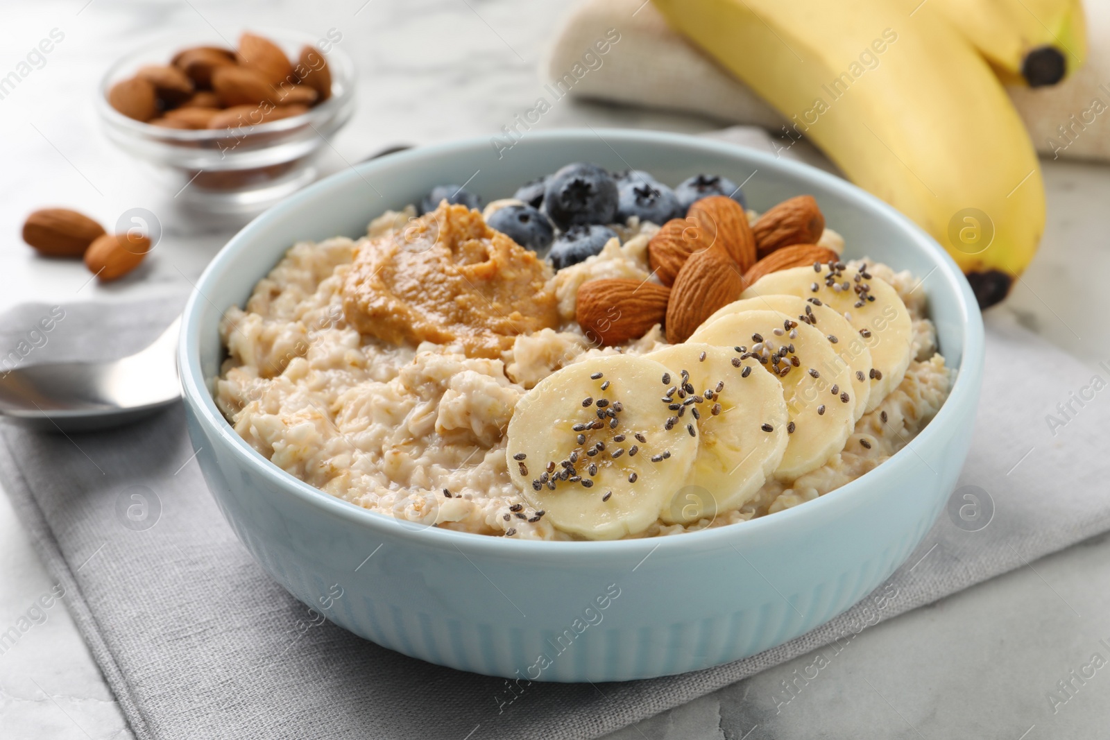 Photo of Tasty oatmeal porridge with toppings served on table