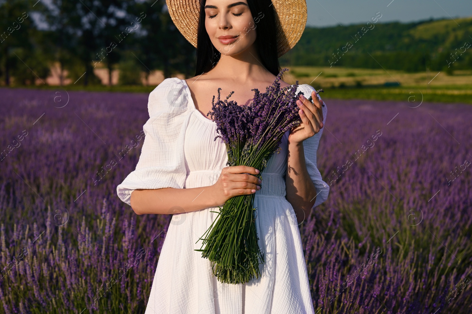 Photo of Beautiful young woman with bouquet in lavender field