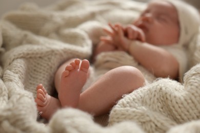 Photo of Adorable newborn baby sleeping at home, focus on legs