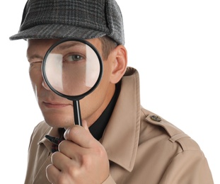 Male detective looking through magnifying glass on white background