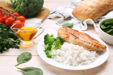 Photo of Grilled chicken breast and rice served with vegetables on wooden table