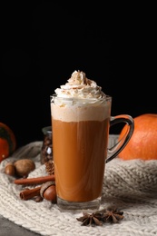 Photo of Glass cup with tasty pumpkin spice latte on table