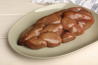 Fresh raw kidney meat on white wooden table, closeup