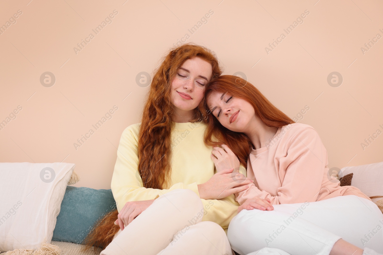 Photo of Portrait of beautiful young redhead sisters in bedroom. Space for text
