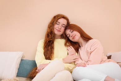 Portrait of beautiful young redhead sisters in bedroom. Space for text