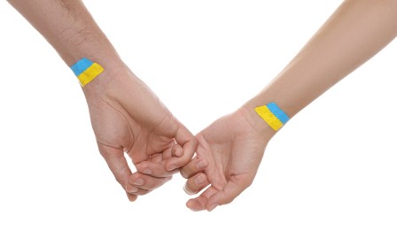 Photo of Man and woman with painted Ukrainian flags on their hands against white background, closeup