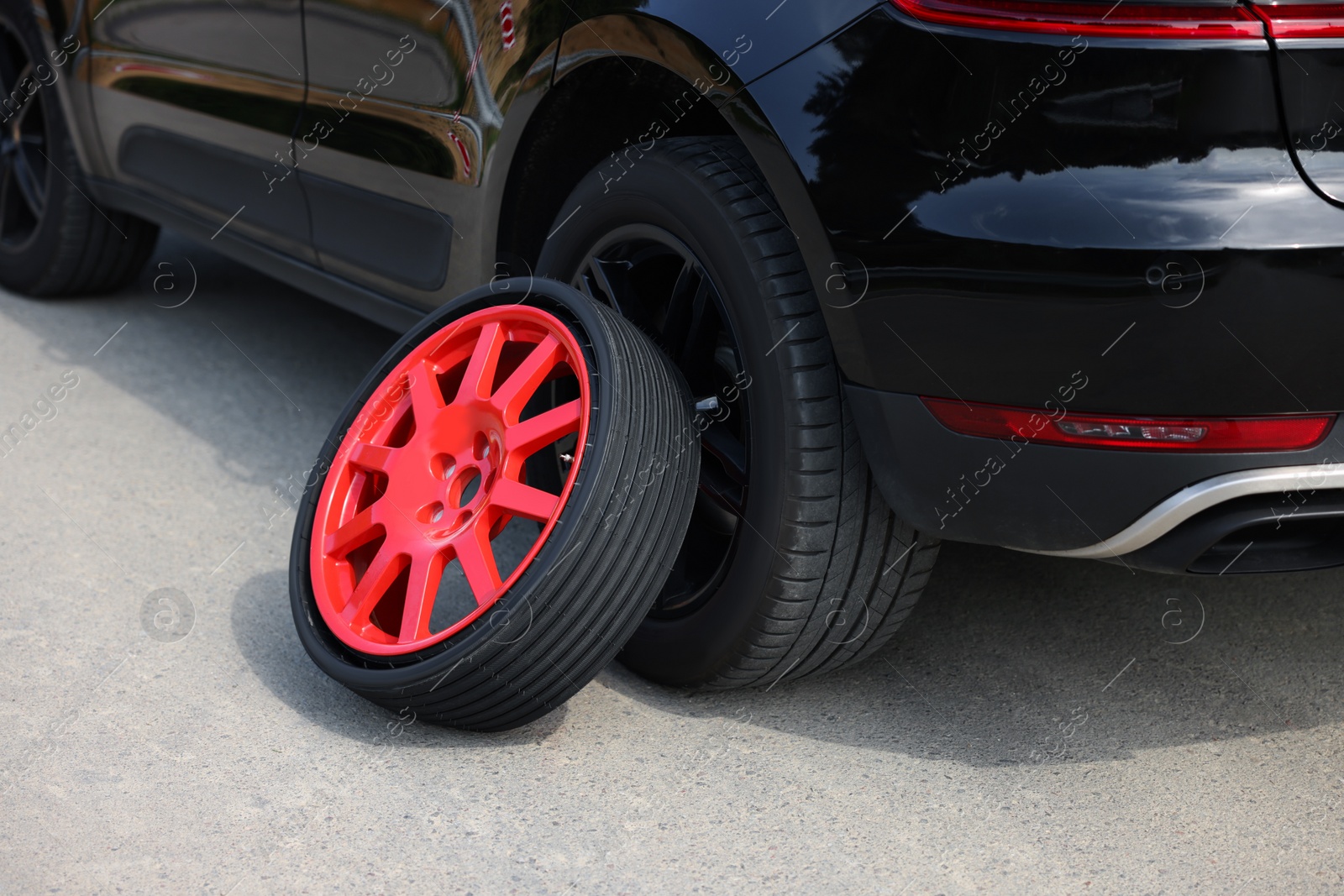 Photo of Tire puncture. New wheel near car on roadside outdoors