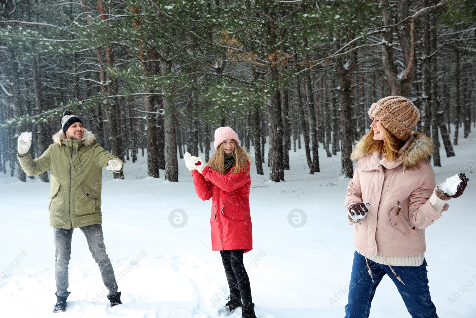 Photo of Happy family playing snowballs in winter forest