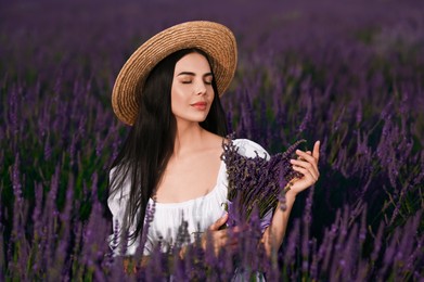 Beautiful young woman with bouquet in lavender field