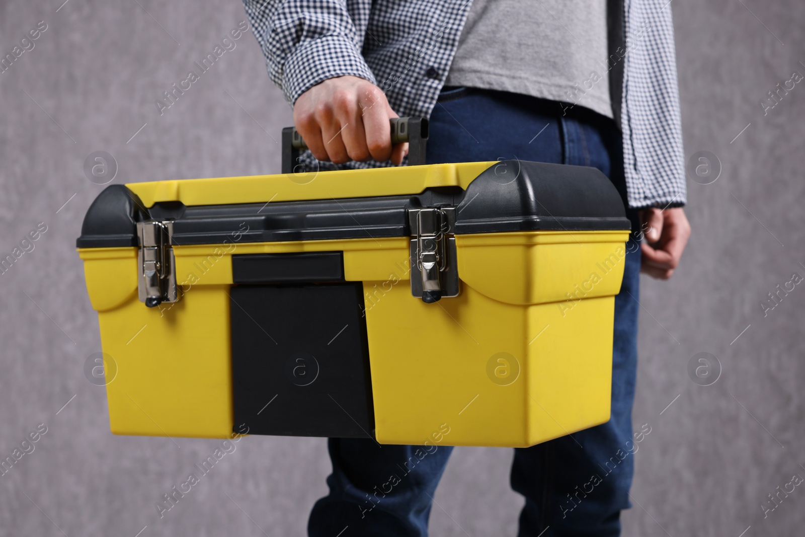 Photo of Young man with tool box on grey background, closeup