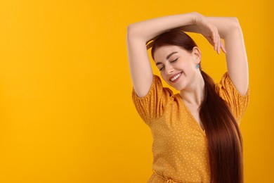 Photo of Portrait of smiling woman on yellow background. Space for text