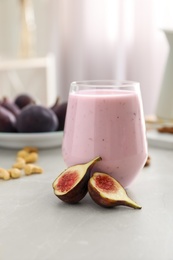 Photo of Delicious fig smoothie in glass on light table