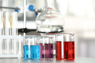 Image of Glass beakers with liquid samples on table. Laboratory analysis